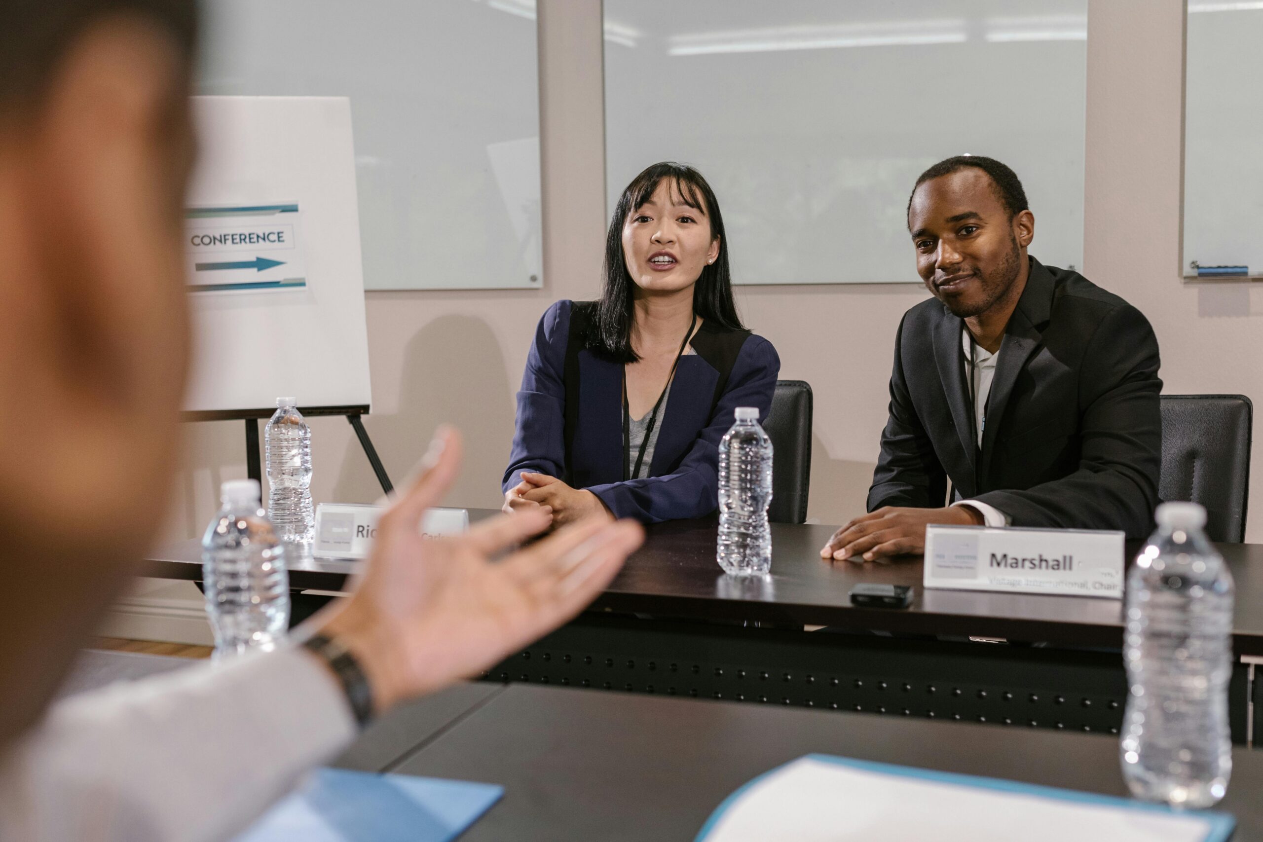 2 people sitting facing an interviewer